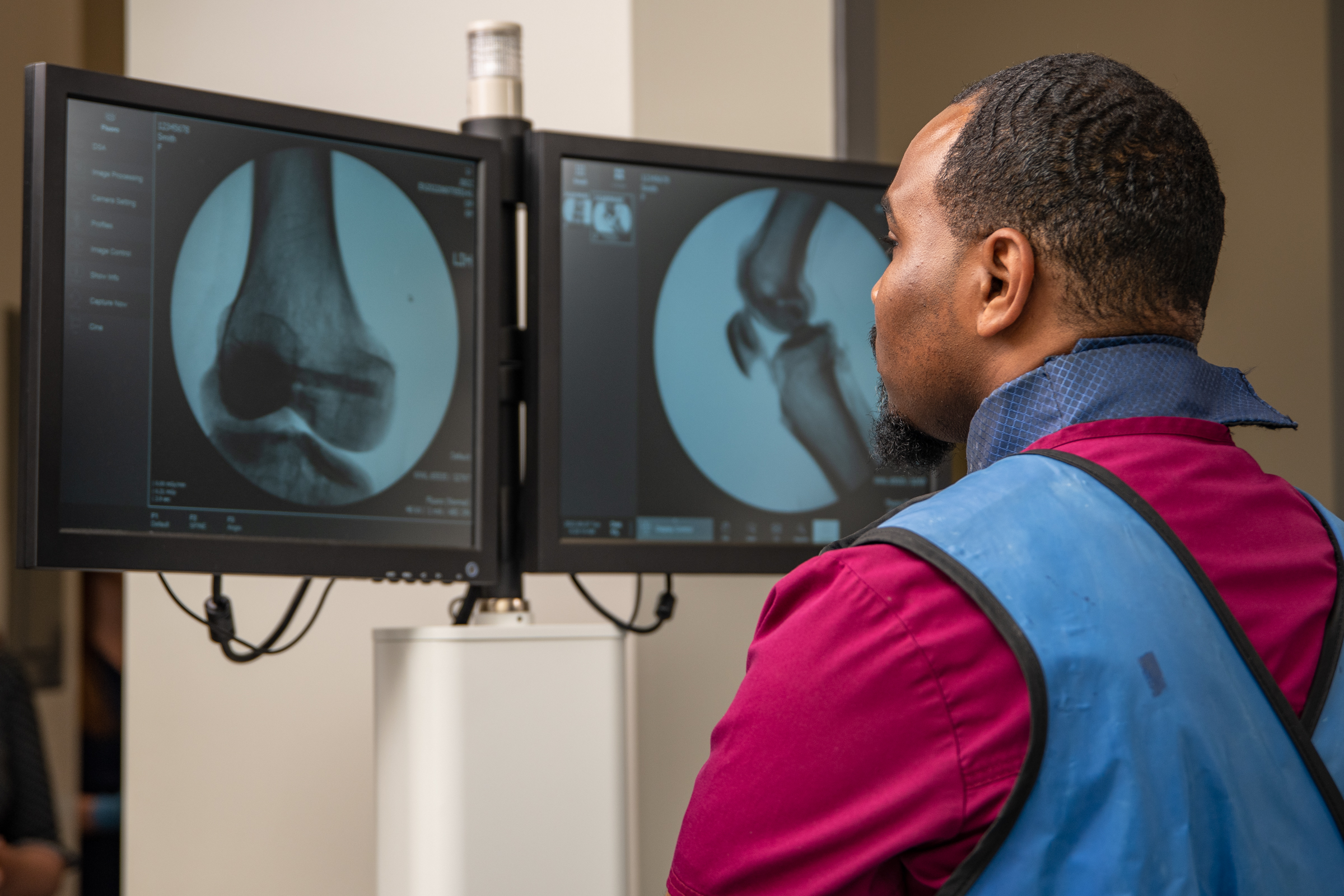 Student looking at x-ray images on a screen in a hospital setting.